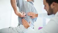 doctor looking at paitent with back pain